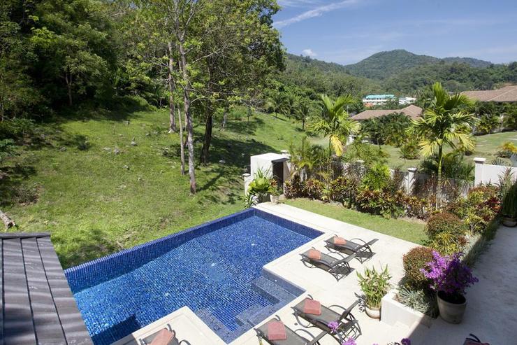Large outdoor balcony overlooks the swimming pool and tranquil valley views