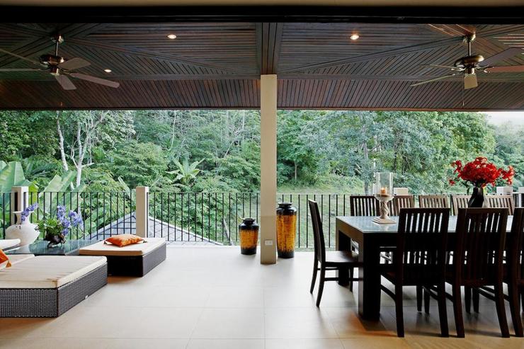 Outside covered balcony, with soft seating and dining table